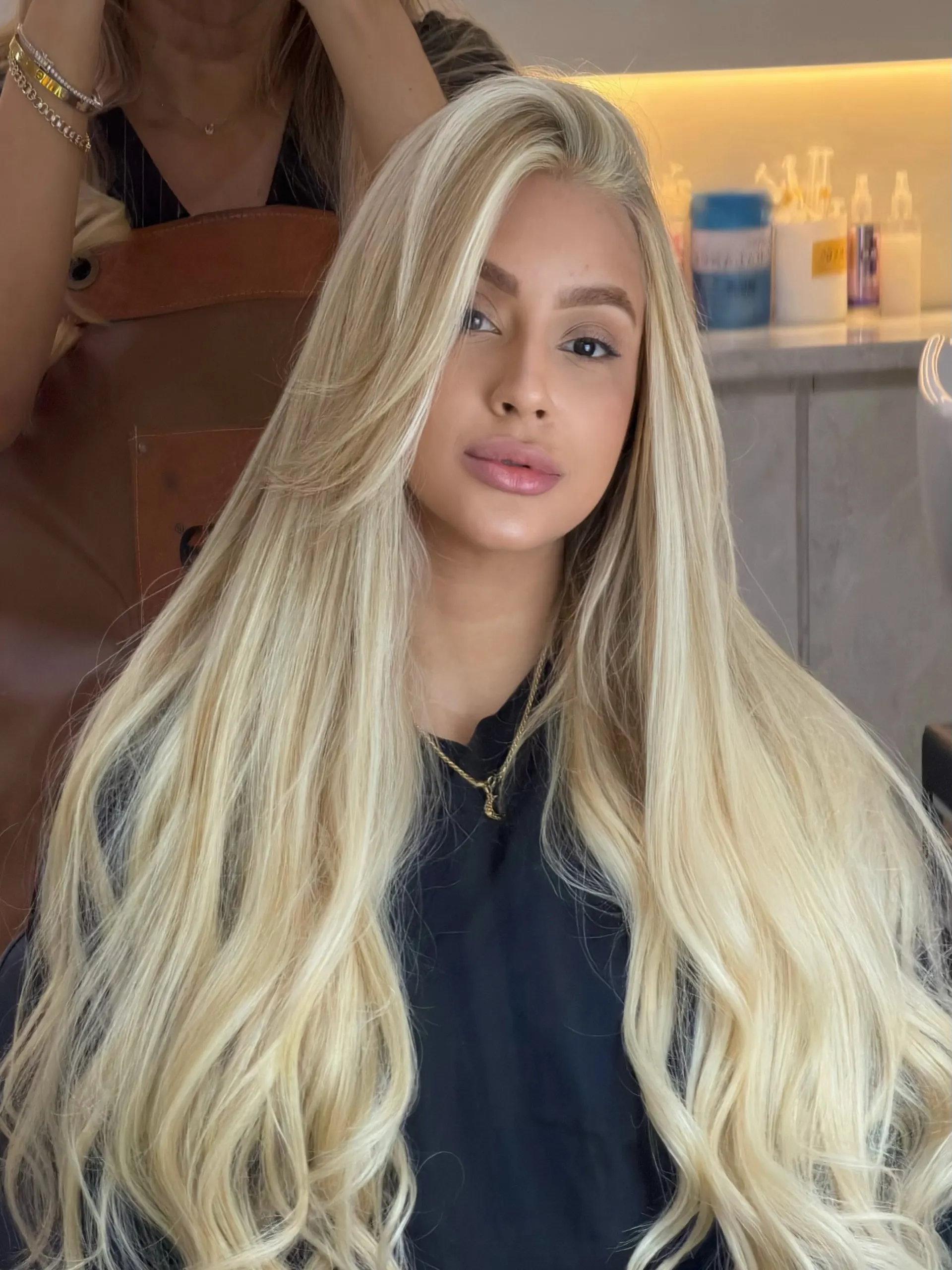 Cliente com cabelo loiro claro longo e liso no salão.